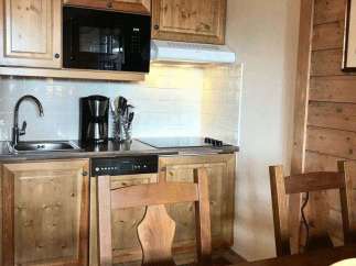 This charming kitchen features rustic wooden cabinetry and a modern microwave.