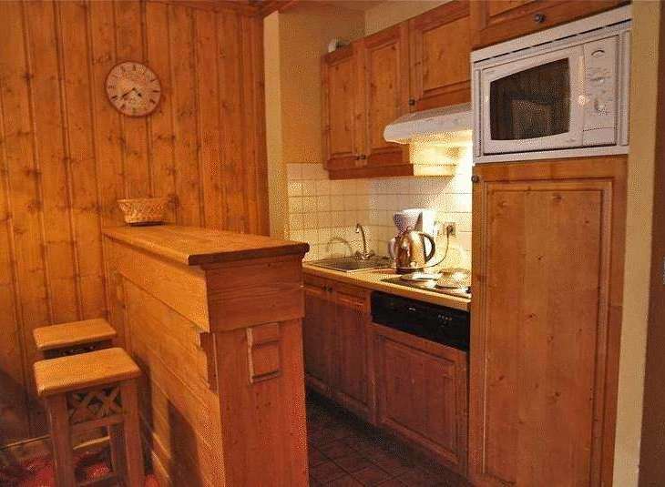 Cozy kitchen with wooden cabinets and a microwave.