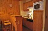 Cozy kitchen with wooden cabinets and a microwave.