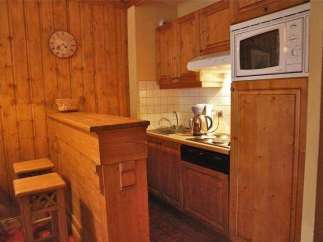 Cozy kitchen with wooden cabinets and a microwave.