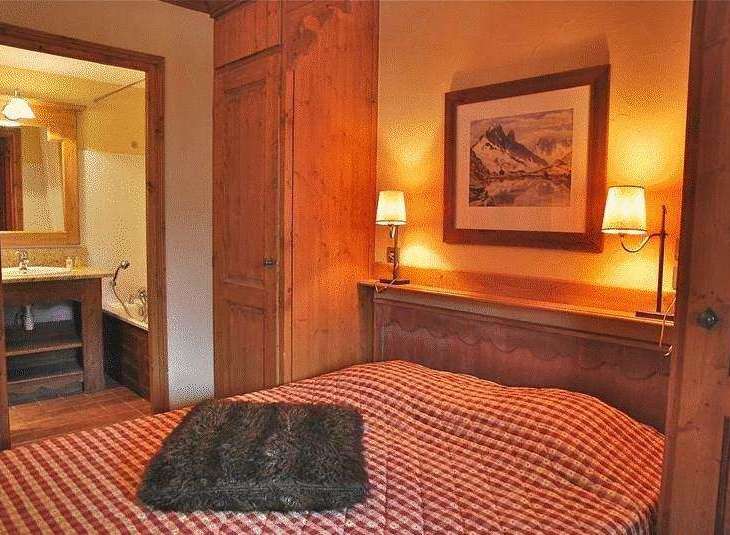Cozy bedroom with a rustic charm, featuring a comfortable bed with a checkered pattern.