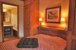 Cozy bedroom with a rustic charm, featuring a comfortable bed with a checkered pattern.