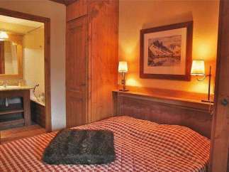 Cozy bedroom with a rustic charm, featuring a comfortable bed with a checkered pattern.