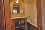 Discover a charming bathroom with a rustic wooden vanity and a built-in bathtub.