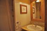 This cozy bathroom features a charming framed artwork and a stylish towel ring.