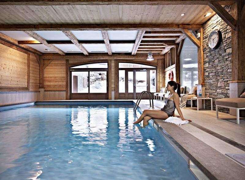Relax and unwind in this luxurious indoor pool, surrounded by rustic wooden beams and a stone accent wall.