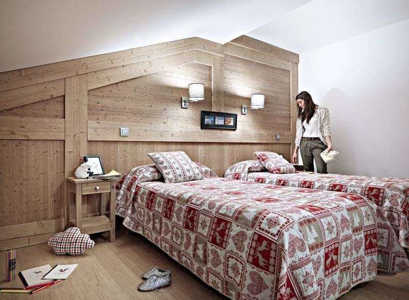 Cozy up in this charming bedroom featuring rustic wooden accents and a warm, inviting atmosphere.