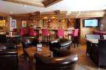 Experience the cozy ambiance of this charming bar, featuring rustic wooden interiors and comfortable seating.