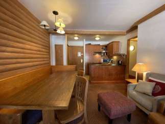 Cozy apartment with a rustic charm, featuring a wooden dining area and a fully equipped kitchen.