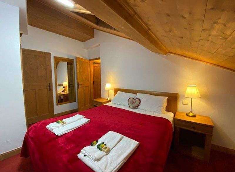 Cozy bedroom with a charming wooden ceiling and walls.