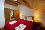 Cozy bedroom with a charming wooden ceiling and walls.