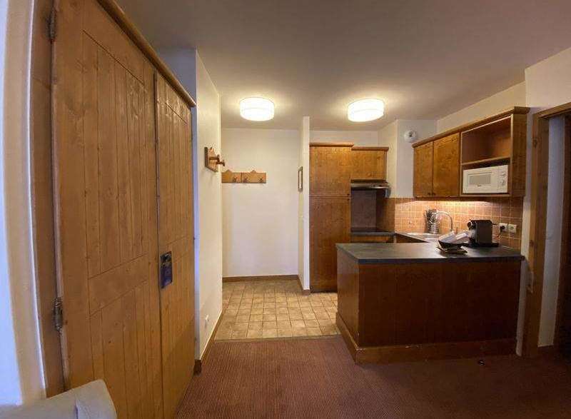 Discover a cozy kitchen with wooden cabinets and a microwave, perfect for preparing meals.