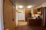 Discover a cozy kitchen with wooden cabinets and a microwave, perfect for preparing meals.