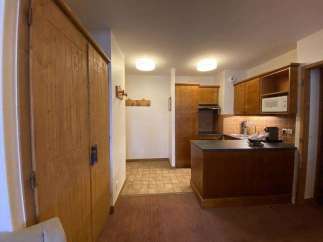 Discover a cozy kitchen with wooden cabinets and a microwave, perfect for preparing meals.