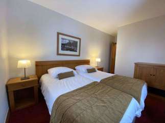 This cozy bedroom features two comfortable beds, perfect for a relaxing stay.