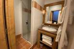 This cozy bathroom features a glass shower, perfect for a refreshing start to your day.