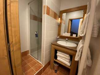 This cozy bathroom features a glass shower, perfect for a refreshing start to your day.