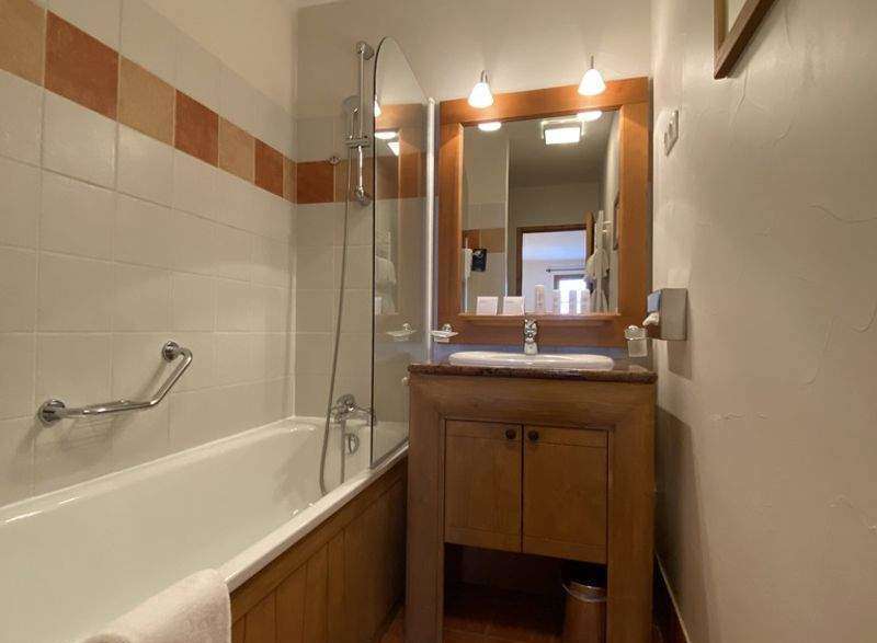This charming bathroom features a classic design with a wooden vanity and a bathtub.