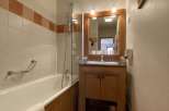This charming bathroom features a classic design with a wooden vanity and a bathtub.