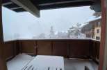 Enjoy breathtaking mountain views from this cozy balcony, perfect for a snowy getaway.