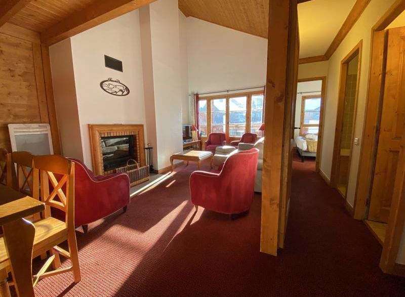 Cozy up in this charming chalet featuring a warm fireplace and inviting red armchairs.