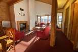 Cozy up in this charming chalet featuring a warm fireplace and inviting red armchairs.