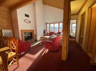 Cozy up in this charming chalet featuring a warm fireplace and inviting red armchairs.