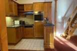 Discover a cozy kitchen with wooden cabinets and a built-in oven, perfect for preparing delicious meals.