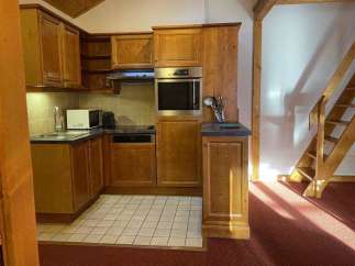 Discover a cozy kitchen with wooden cabinets and a built-in oven, perfect for preparing delicious meals.