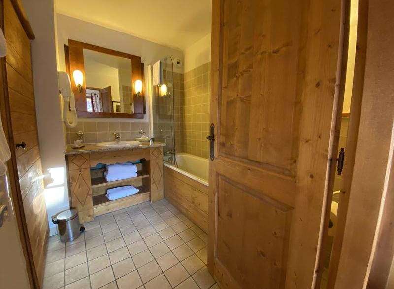 This charming bathroom features a rustic wooden vanity and a matching wooden door, creating a warm and inviting atmosphere.