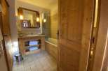 This charming bathroom features a rustic wooden vanity and a matching wooden door, creating a warm and inviting atmosphere.
