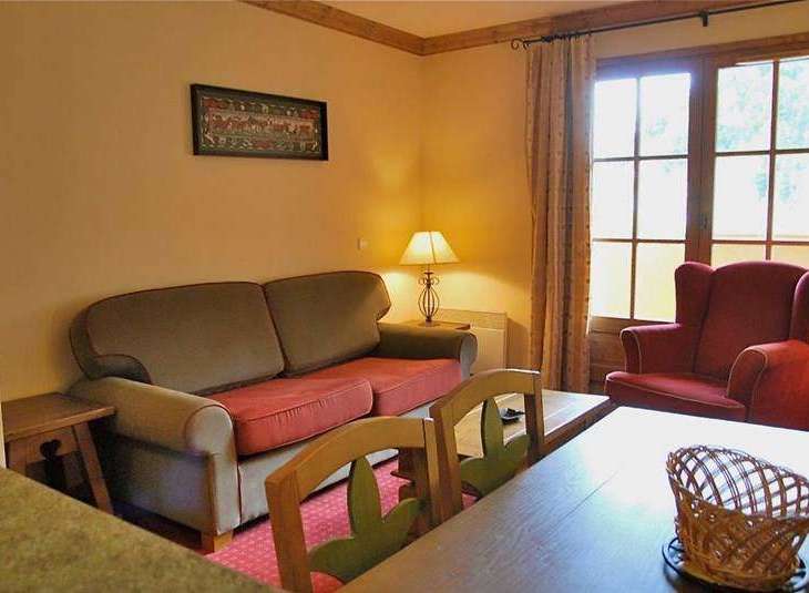 Cozy living space with a comfortable sofa and a charming red armchair.