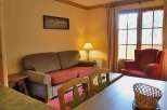 Cozy living space with a comfortable sofa and a charming red armchair.