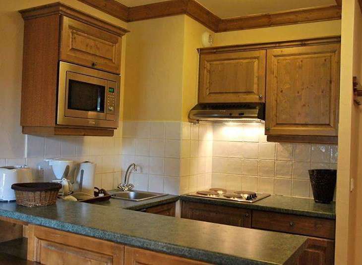 This charming kitchen boasts a microwave and range hood, perfect for preparing meals.