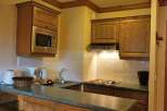 This charming kitchen boasts a microwave and range hood, perfect for preparing meals.