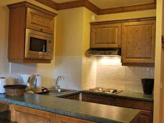 This charming kitchen boasts a microwave and range hood, perfect for preparing meals.