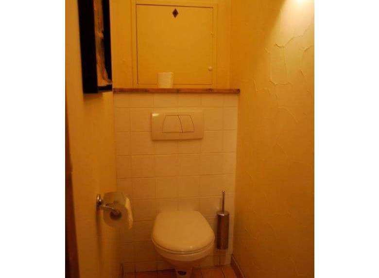 This cozy bathroom features a classic toilet design.