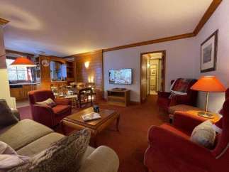 Cozy living space with a warm ambiance, featuring comfortable seating and a charming fireplace.