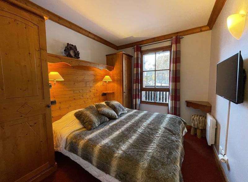 Cozy bedroom with wooden accents and a comfortable bed.
