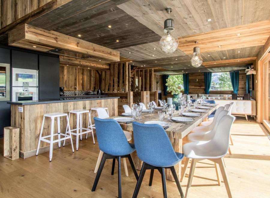 Experience luxury living in this stunning property, featuring a beautifully designed dining area with a rustic wooden aesthetic.