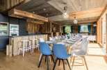 Experience luxury living in this stunning property, featuring a beautifully designed dining area with a rustic wooden aesthetic.