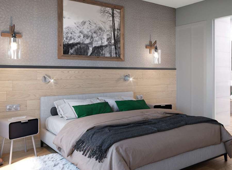 This stunning bedroom boasts a cozy and modern design, featuring a plush bed with a soft throw blanket and stylish green pillows.