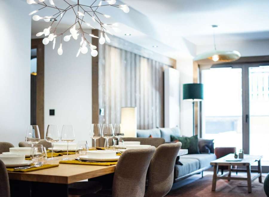 This stunning apartment boasts a spacious open-plan living area with a modern dining setting, perfect for entertaining guests.