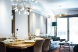 This stunning apartment boasts a spacious open-plan living area with a modern dining setting, perfect for entertaining guests.