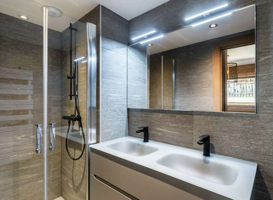 Modern bathroom with double sinks and a walk-in shower.