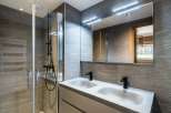 Modern bathroom with double sinks and a walk-in shower.