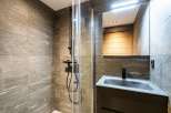 Modern bathroom with sleek, dark fixtures and a glass shower enclosure.