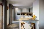 Step into this modern kitchen, featuring sleek cabinetry and a stylish island.