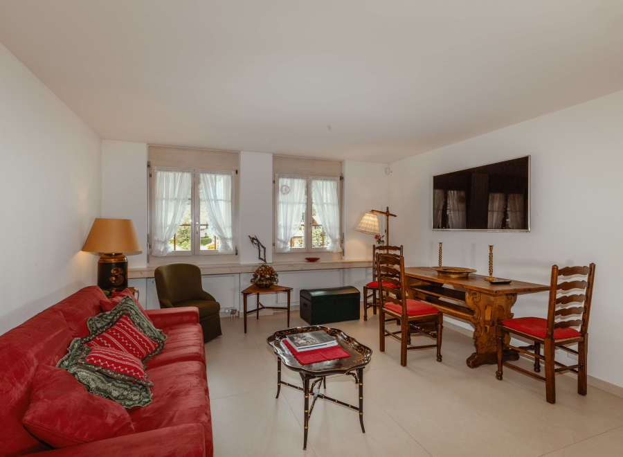 This charming living space features a cozy red sofa, perfect for relaxing.