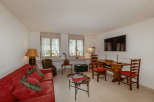This charming living space features a cozy red sofa, perfect for relaxing.